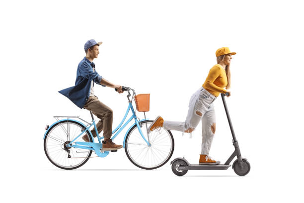 istock Young female riding an electirc scooter and guy riding a bicycle 1569409458