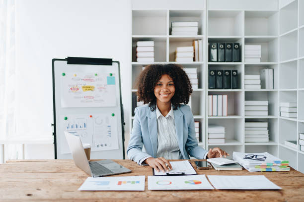 istock American African business woman using document, computer laptop, calculator, paperwork, documents, in winner and smiling Happy to be successful achievement success. finance and investment concepts 1569411959