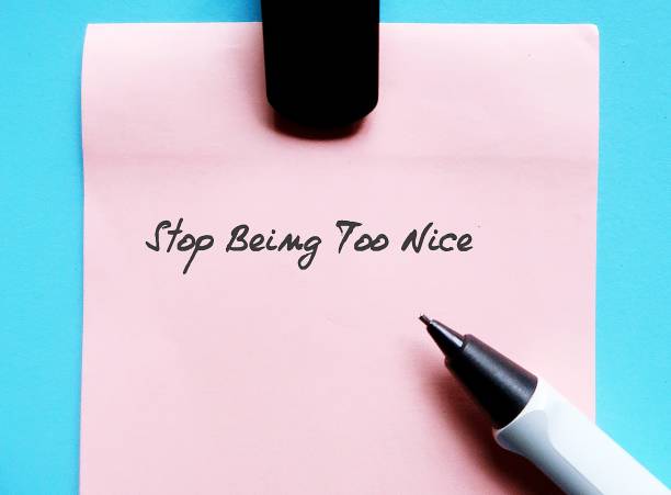 istock Pink note on blue background with handwriting STOP BEING TOO NICE, or stop being People Pleaser, prioritize your self-respect over kindness to people who not deserve it 1569414150