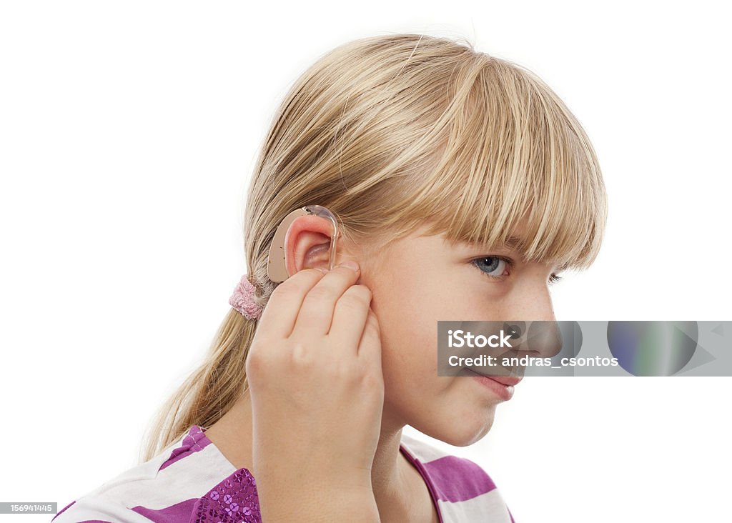 Hearing Aid and a girl Teen girl wearing a hearing aid. Studio shot-isolated on white background. Adult Stock Photo