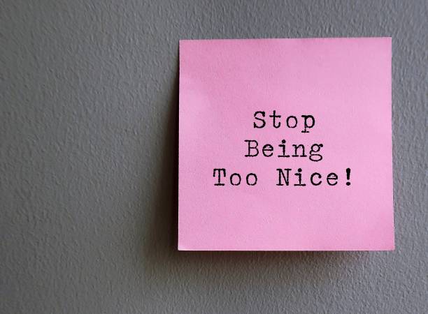 istock Pink note on wall with text STOP BEING TOO NICE - concept of self reminder to stop trying so hard to be nice , pleasing those around you to seek acceptance or approval, start setting boundary and speak your mind 1569414696