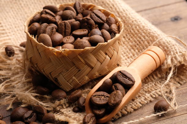 coffee bean is a seed of the Coffea plant and the source for coffee. coffee beans in a woven bamboo container. biji kopi. wooden spoon. coffee bean is a seed of the Coffea plant and the source for coffee. coffee beans in a woven bamboo container. biji kopi biji kopi stock pictures, royalty-free photos & images