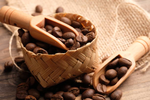 coffee bean is a seed of the Coffea plant and the source for coffee. coffee beans in a woven bamboo container. biji kopi. wooden spoon. coffee bean is a seed of the Coffea plant and the source for coffee. coffee beans in a woven bamboo container. biji kopi biji kopi stock pictures, royalty-free photos & images
