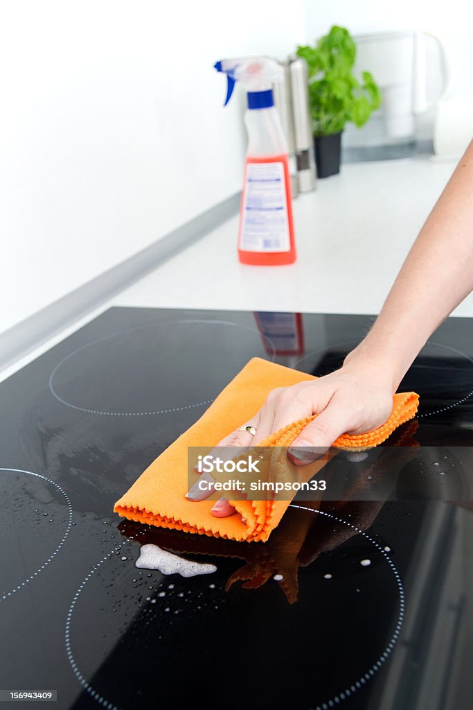 Hand cleaning induction stove Cleaner Stock Photo
