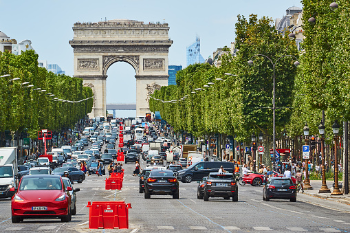 Paris, France - July 10, 2023: Traffic on the Champs Elysees in front of the Arc de Triomphe.