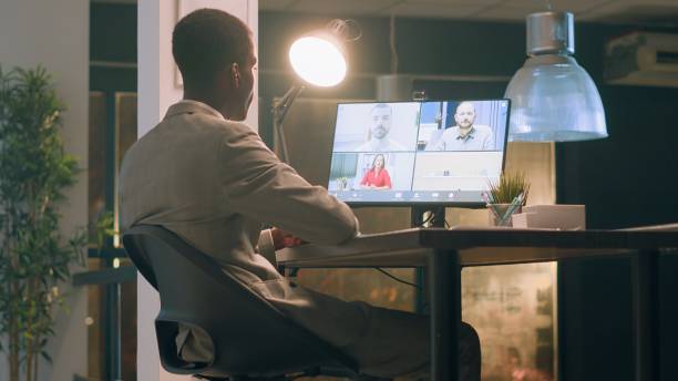 istock Manager greeting employees in videocall 1569446137