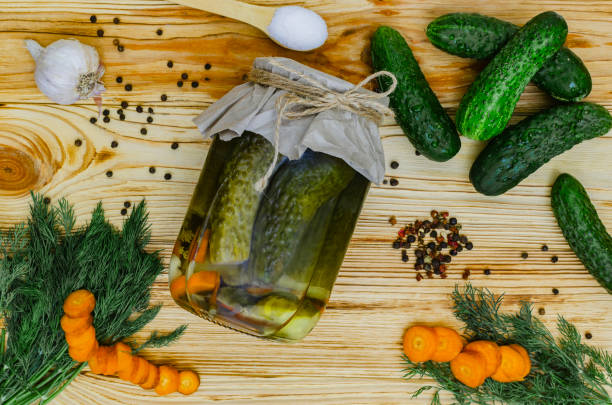 istock Pickled cucumbers on wooden background 1569448334
