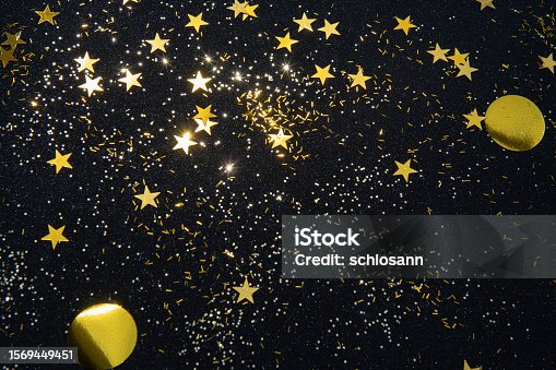 istock gold star confetti and glitter on a black glitter background for a Christmas project 1569449451