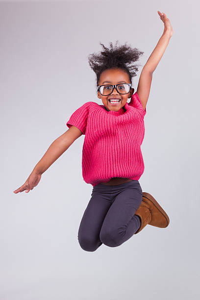 A portrait of a young girl jumping up and making a pose stock photo