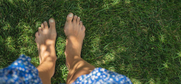 istock Close up female legs walking on the grass 1569466040
