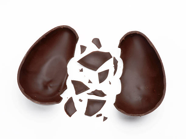 Chocolate Easter egg cracked in several big and small pieces stock photo