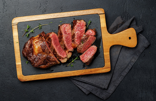Deliciously juicy sliced beef ribeye steak, perfectly cooked and ready to be savored. Flat lay