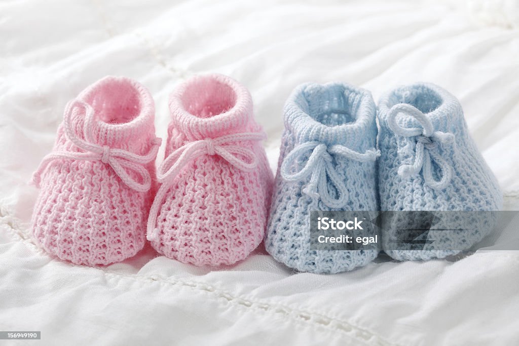 Close-up of pink and blue crocheted baby shoes Blue and pink baby booties on white background Baby Booties Stock Photo