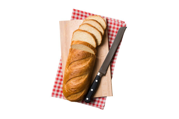 istock Freshly baked bread cut with knife isolated on white background . top view Sliced bread and knife 1569492401