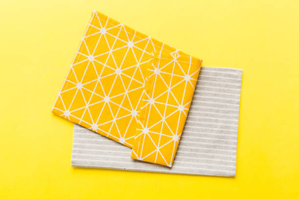 istock top view with yellow empty kitchen napkin isolated on table background. Folded cloth for mockup with copy space, Flat lay. Minimal style 1569494557