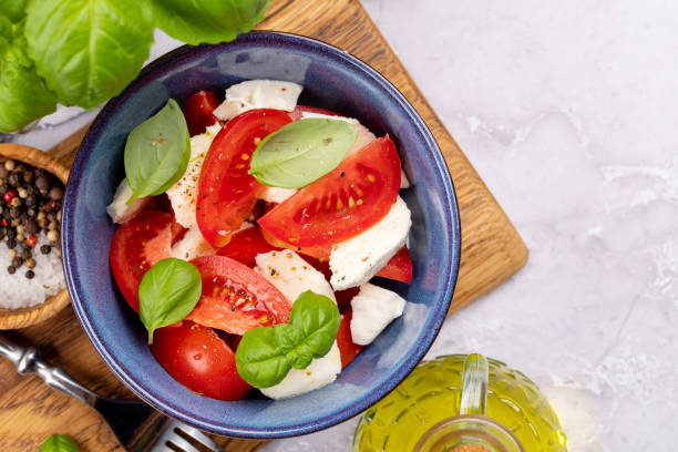 istock Caprese salad with ripe tomatoes, mozzarella cheese and garden basil 1569501104