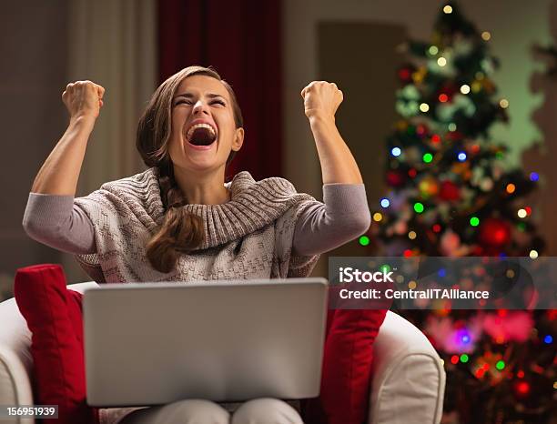 Happy Woman With Laptop Rejoicing Success Near Christmas Tree Stock Photo - Download Image Now