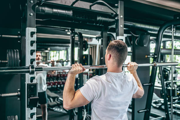 istock Young man exercising with barbell 1569536197