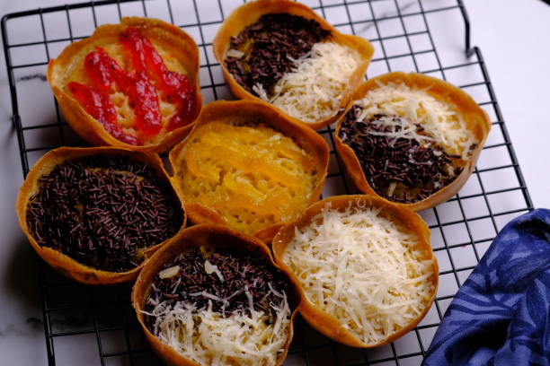 martabak manis. martabak doce. lanche doce feito de farinha, ovos, baunilha, coberto com queijo ralado, chocolate e geleia de abacaxi, geleia de morango. servido em uma prateleira de resfriamento. comida indonésia. - mm21 - fotografias e filmes do acervo