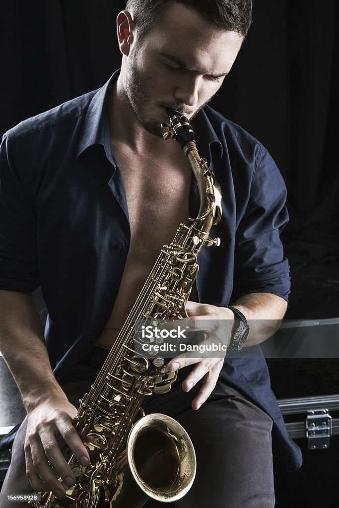 Young man playing the Saxophone. Young man playing jazz on the Saxophone. Adult Stock Photo