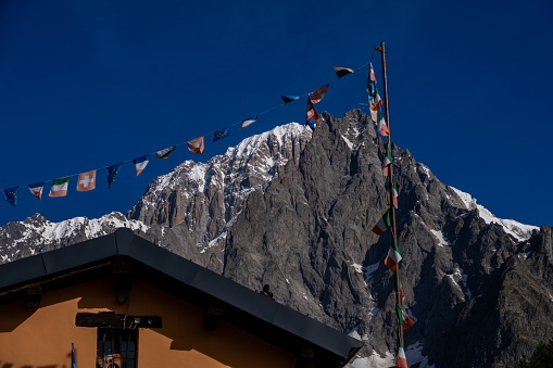 Refuge in front of flags and a mountain