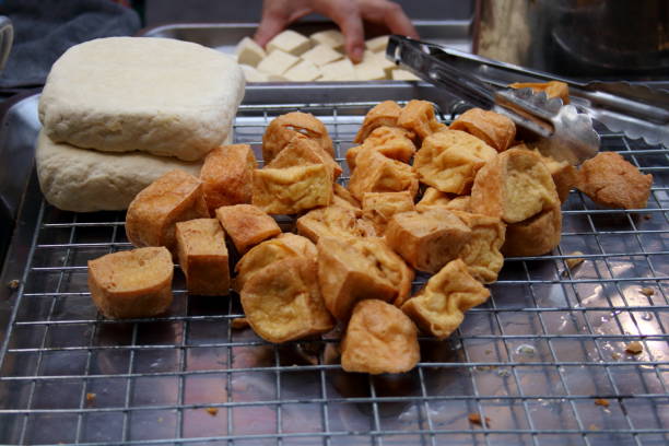 istock Deep fried tofu on metal grate. 1569599829