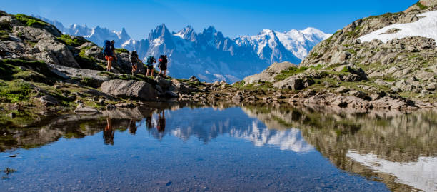 reflet de randonneurs dans un lac alpin - mont blanc massif photos et images de collection