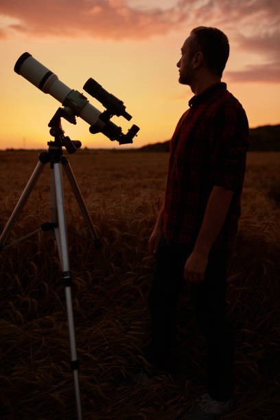 istock Astronomer looking at sky with a telescope. 1569614739