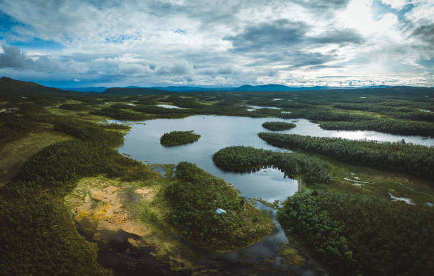 istock Sunset over lakes surrounded by green forest 1569615268
