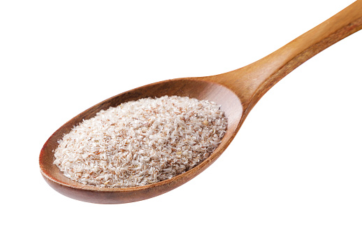 Psyllium in a wooden spoon close-up on a white background. Isolated
