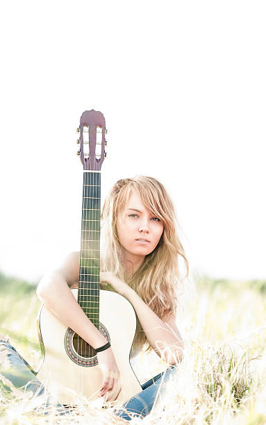 istock Beautiful woman with guitar sitting on grass. 156966741