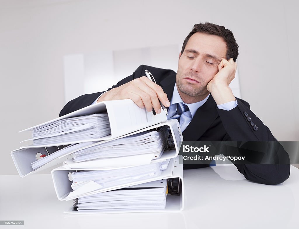 Bored Businessman Bored Businessman Overwhelmed By Paperwork In The Office Adult Stock Photo