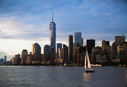 Manhattan skyline, including One World Trade Centre (the freedom tower), as seen from the water with boat sailing in New York City.