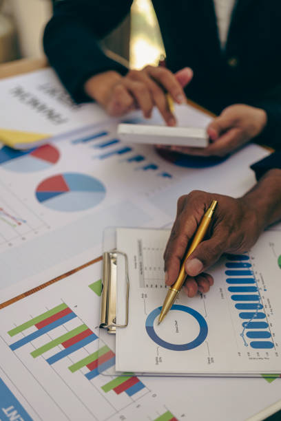 istock vertical image Business financial analyst on investment project planning digital tablet during discussion at corporate meeting showing successful teamwork 1569692814
