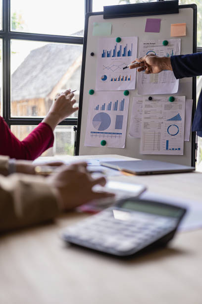 istock vertical image Business financial analyst on investment project planning digital tablet during discussion at corporate meeting showing successful teamwork 1569692929