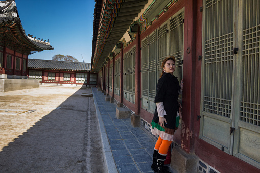 A young women is posing in Gyeongbokgung Palace during Joseon Dynasty. Gyeongbokgung Palace or Gyeongbok Palace, was the main royal palace of the Joseon dynasty. Built in 1395, it is located in northern Seoul, South Korea.
