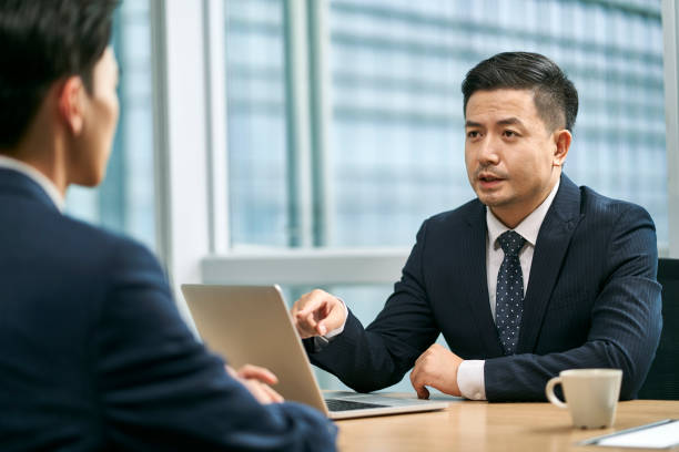 istock asian corporate executives discussing business in office 1569737759