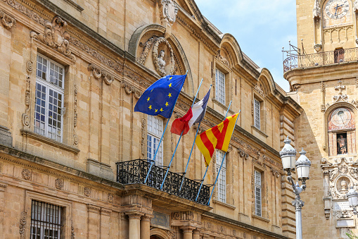 Aix-en-Provence, France - August 30, 2018: View of Tower and Hotel de Ville in Aix en Provence with Flags on building
