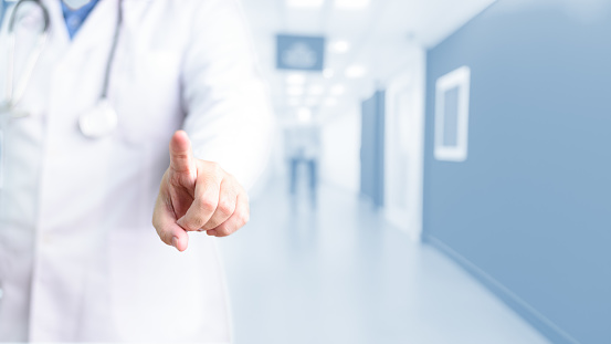 Doctor clicking touching index point finger gesture health care blue blurry hospital background copy space. People lifestyle medical personnel occupation concept. Health insurance and welfare theme.