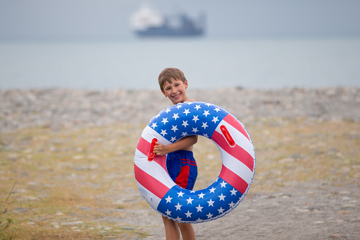 Summer background with flip flops of American flag colors and pattern near the swimming pool