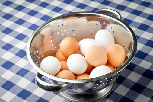Dozen Eggs in stainless steel colander or Bowl on Blue Gingham