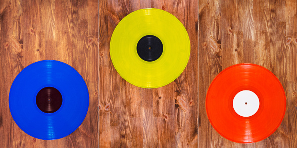 Collection of images with different color vinyl records on brown wooden background