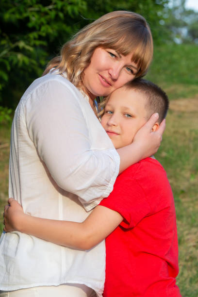 istock Happy mom and son hugging on a summer walk. 1569753722