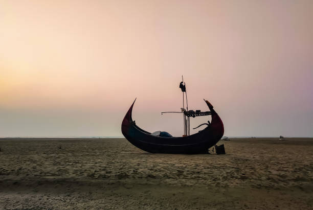 Moon shaped fishing boat A moon shaped fishing boat on the Cox's Bazaar Sea beach, Bangladesh bay of bengal stock pictures, royalty-free photos & images