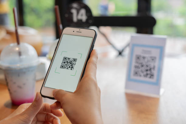 istock Woman use smartphone to scan QR code to pay in cafe restaurant with a digital payment without cash. Choose menu and order accumulate discount. E wallet, technology, pay online, credit card, bank app. 1569762317