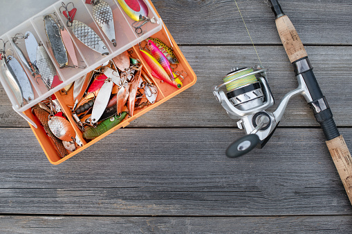 Fishing tackle for fishing fish. Spinning in a composition with accessories for fishing on a wooden background on the table