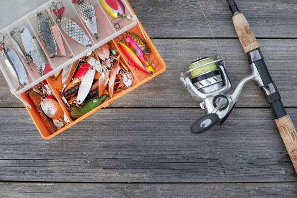 Fishing tackle for fishing fish. Spinning in a composition with accessories for fishing on a wooden background on the table. stock photo