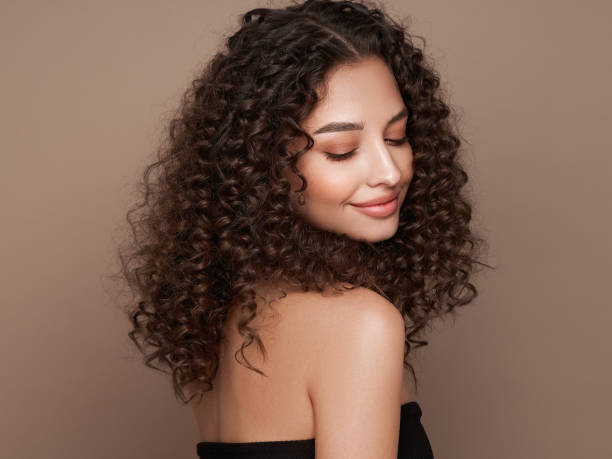 istock Beautiful smiling woman with afro curls 1569774393