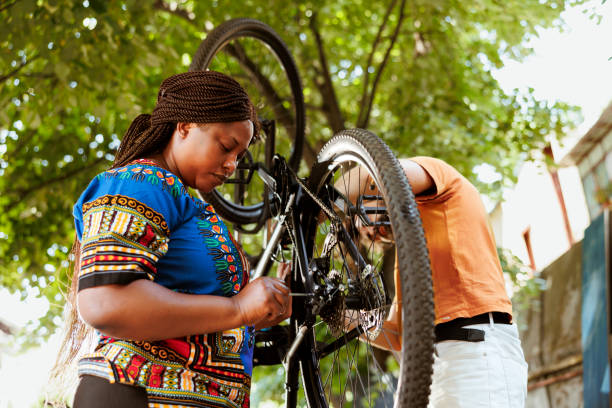 istock Multiethnic couple mending bicycle 1569787012
