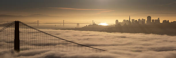 golden gate bridge, san francisco skyline em sunrise - san francisco county bridge california fog imagens e fotografias de stock